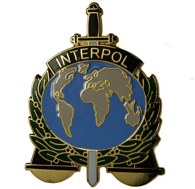 Distintivo Interpol. Fonte wikimedia commons.