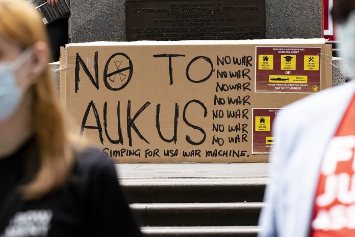 Cartellone contro il patto Aukus durante una manifestazione Fonte: Wikimedia Commons